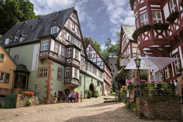 MainZauber Apartments früher MainTerrasse Miltenberg am Main - Entdecken Sie eine luxuriöse Ferienwohnung in einer bezaubernden europäischen Umgebung, perfekt für Ihren nächsten Kurzurlaub. Diese Unterkunft liegt in einer bezaubernden Kopfsteinpflasterstraße mit mittelalterlichen Fachwerkhäusern und bietet nicht nur einen Platz zum Übernachten, sondern ein komplettes Erlebnis. Wenn Sie die malerische Gegend bei teilweise bewölktem Himmel erkunden, finden Sie lebhafte Cafés mit Sonnenschirmen und leuchtenden Blumen entlang der Straßen. Egal, ob Sie Entspannung oder Abenteuer suchen, unsere Ferienwohnung bietet einen unvergesslichen europäischen Kurzurlaub.