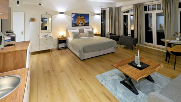 MainZauber Apartments früher MainTerrasse Miltenberg am Main - Entdecken Sie mit diesem luxuriösen, modernen Studio-Apartment die ultimative Urlaubsunterkunft. Dieses geräumige Studio ist perfekt für Ihren nächsten Urlaub. Es verfügt über atemberaubende Holzböden und bietet einen gemütlichen Schlafbereich mit einem weichen Bett, Nachttischen, einer schicken Kommode und einem eleganten Wandspiegel. Entspannen Sie sich im bequemen Sitzbereich mit stilvollen Sesseln und einem hölzernen Couchtisch, der durch große Fenster mit eleganten Vorhängen in natürliches Licht getaucht ist. Machen Sie es zu Ihrem idealen zweiten Zuhause in Ihrem nächsten Urlaub!